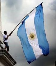 La bandera argentina flameando en un mástil que porta un ciudadano La bandera argentina flameando en un mástil que porta un ciudadano
